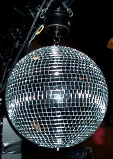 disco ball: a suspended rotating mirrored sphere which casts moving spots of light across a room when light is...