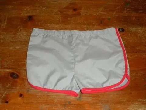dolphin shorts: a type of short athletic shorts with curved side slits and a contrasting trim, resembling the shape...