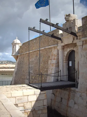 drawbridge: a hinged bridge which can be raised (to prevent its being crossed, as across a moat, or to allow...