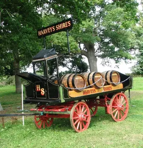 dray: any of various forms of low horse-drawn cart or wagon, often without sides or with removable sides,...