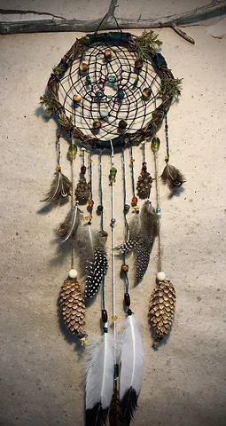 dreamcatcher: a decorative Native American object in the form of a hoop and net with attachments such as...