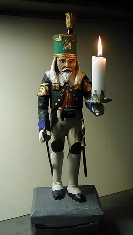 miner's figure: a wooden figure of a miner, usually bearing one or two candles, traditionally used as a Christmas...