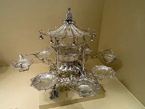 epergne: a table centerpiece, usually made of silver, generally consisting of a central bowl with radiating...