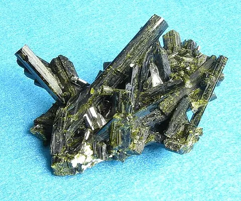 epidote: any of a class of mixed calcium iron aluminium sorosilicates found in metamorphic rocks
