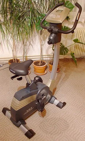 exercise bicycle: a stationary exercise machine with pedals, saddle, handlebars arranged like a bicycle