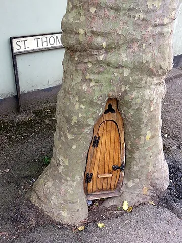 fairy door: a miniature door, usually set into the base of a tree, behind which may be a small space where...