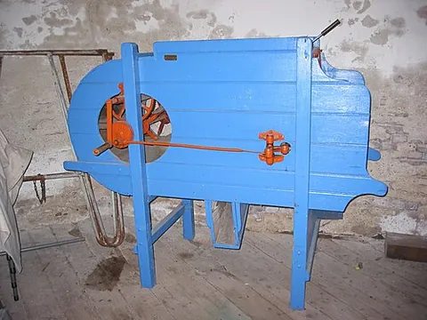 fanning mill: a device using an air blast to winnow grain, using riddles and sieves