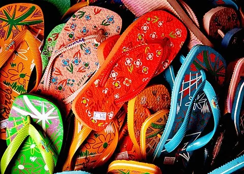 flip-flop: a sandal consisting of a rubber sole fastened to the foot by a rubber thong fitting between the...