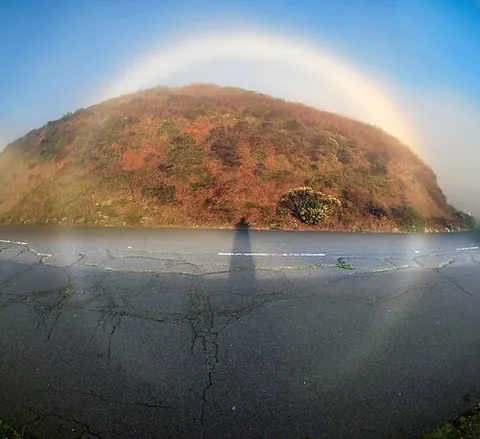 fogbow: a white arc or circle, similar to a rainbow, which can appear in the sky in foggy conditions as...
