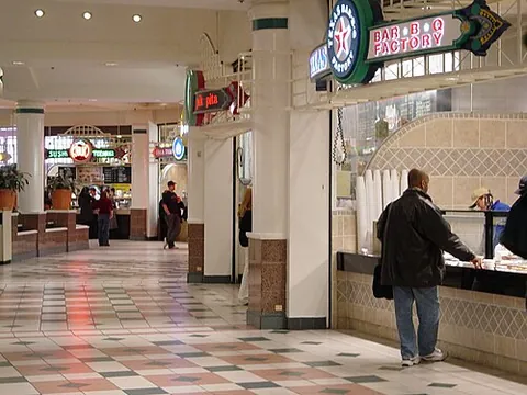 food court: a common area for dining, containing or surrounded by contiguous counters of multiple food vendors,...