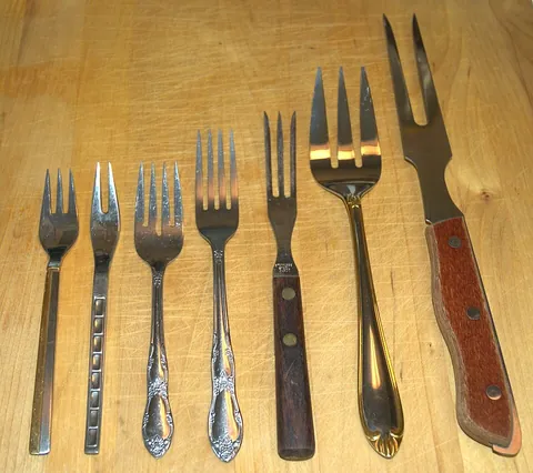 fork: a utensil with spikes used to put solid food into the mouth, or to hold food down while cutting, or...
