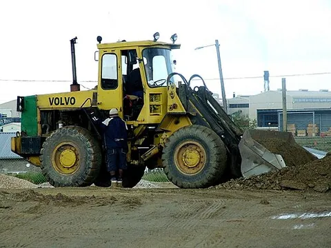 front-end loader: a type of four-wheeled tractor, used in construction, which has a one-man cabin and a large scoop...
