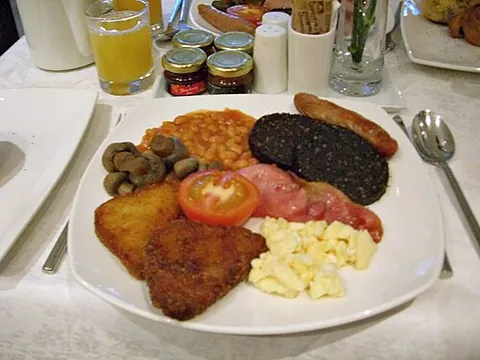 fry up: a breakfast made of tomatoes, scrambled eggs, fried eggs, bacon, sausages, hash browns, baked...
