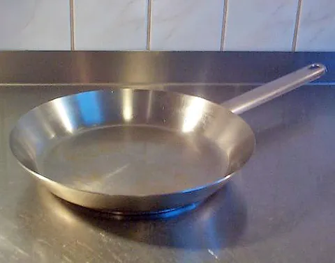 frying pan: a long-handled, shallow pan used for frying food