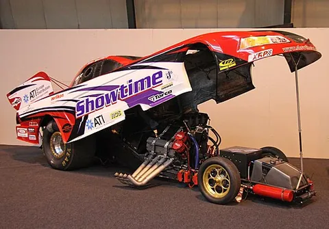 funny car: a drag racing car of a class generally having forward-mounted engines and carbon fiber automotive...