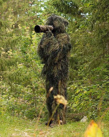 ghillie suit: a type of overall covered in torn cloth shreds (faux foliage), used as camouflage by hunters and...
