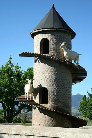 goat tower: a decorative, multi-story structure built for goats to live in and climb; often inspired by...