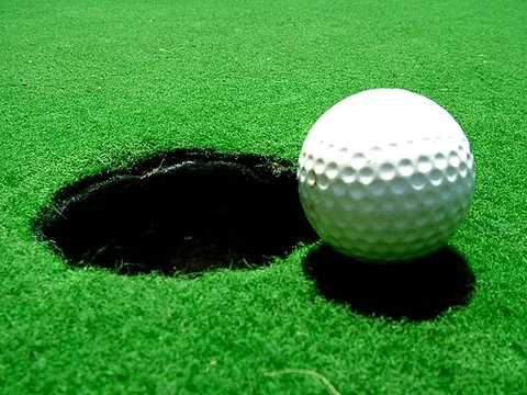 golf ball: a small, usually white ball that is designed for use in the game of golf
