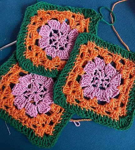 granny square: a piece of square fabric produced by crocheting in rounds from the centre outward