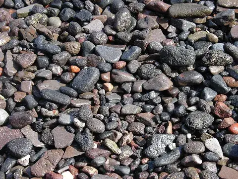 gravel: small fragments of rock, used for laying on the beds of roads and railways, and as ballast