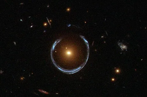 gravitational mirage: a distorted or false image of a distant galaxy (e.g. an image of a distant galaxy as a ring, or as...