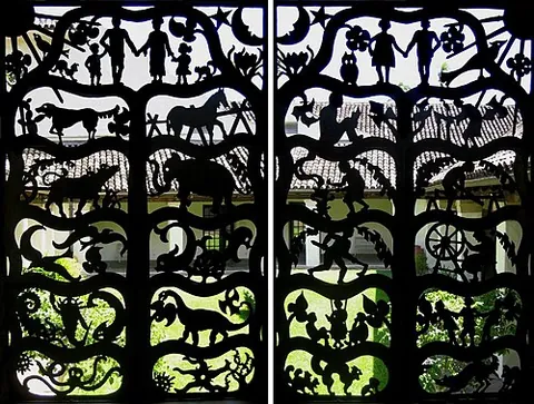 grillwork: the mesh of metal wire or bars which makes up a decorative metal grating