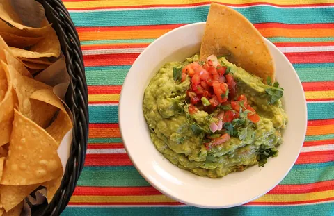 guacamole: an avocado-based greenish dip with onions, tomato, and spices, common to Mexican cuisine and often...