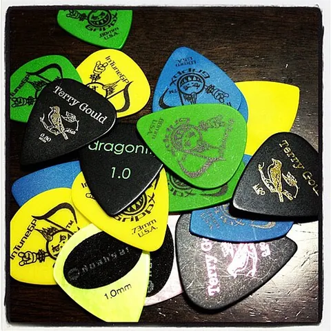 guitar pick: a small piece of plastic, metal, ivory, etc., for plucking the strings of a guitar, lyre, mandolin,...
