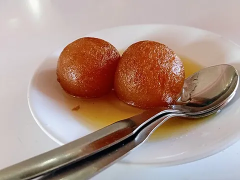 gulab jamun: a South Asian dessert made from milk solids that are deep-fried and soaked in syrup
