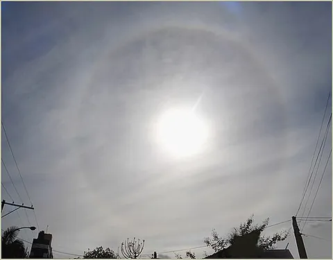 halo: a circular band of coloured light, visible around the sun or moon etc., caused by reflection and...