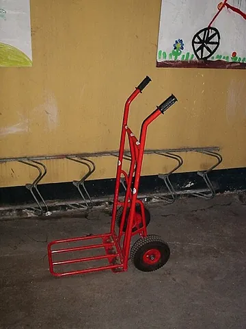 hand truck: an L-shaped box-moving handcart with handles at one end, wheels at the base, with a small ledge to...
