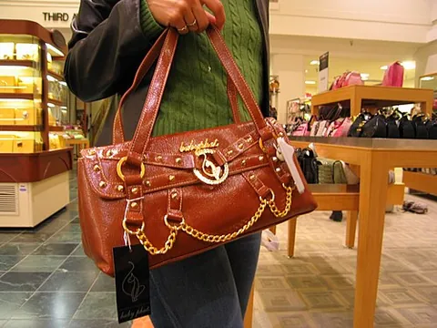 handbag: a small bag carried in the hand, used either when travelling or to carry tools for a specific job