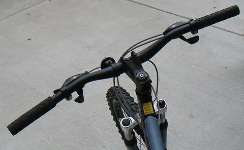 handlebar: the bar used to steer a bicycle, motorbike, or similar vehicle using the hands