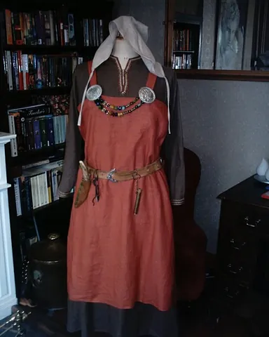 hangerock: a dress or apron, often wider at the bottom than at the top, held up by straps passing from the...