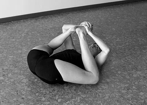 happy baby: a pose where the person lays on their back with legs bent and feet apart, and holds the ends of the...