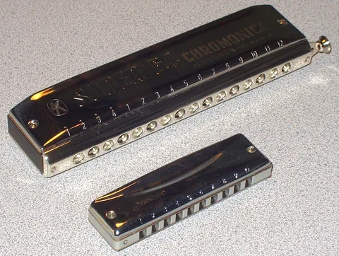 harmonica: a musical wind instrument with a series of holes for the player to blow into, each hole producing a...