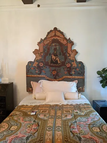 headboard: a vertical panel, either plain or upholstered, attached to the head of a bed