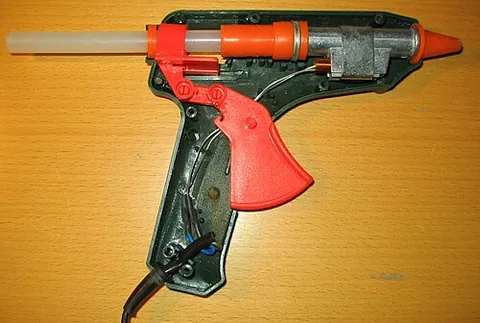 hot glue gun: a gun-shaped tool with a heating element, used to apply hot melt adhesives