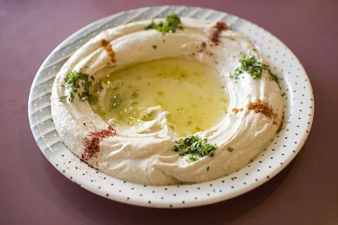 hummus: a Levantine Arab dip made of chickpea paste with various additions, such as olive oil, fresh...