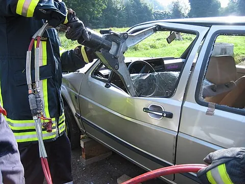 jaws of life: emergency rescue equipment used to open a severely damaged passenger vehicle with a strong...