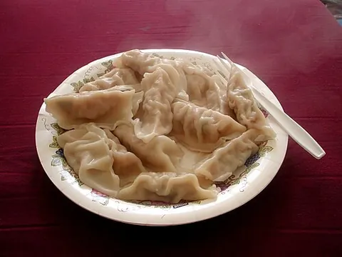 jiaozi: a Chinese crescent-shaped dumpling filled with a minced stuffing and steamed, boiled or fried; the...