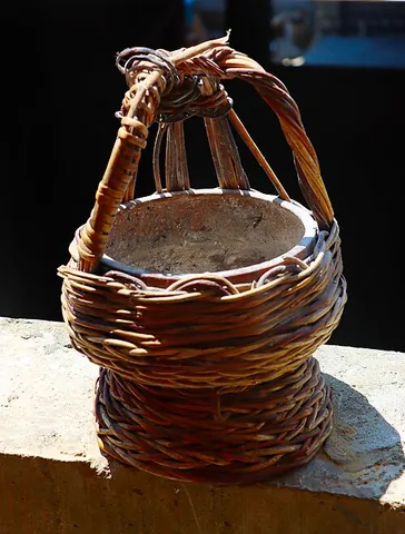 kangri: a small wicker-covered clay pot containing hot coals, worn under clothing in Kashmir to warm the...
