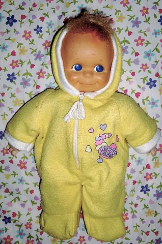 kewpie doll: a plump doll with a curl of hair on its head
