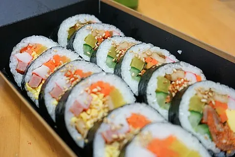kimbap: a Korean dish of steamed white rice and other ingredients rolled in sheets of dried laver seaweed...