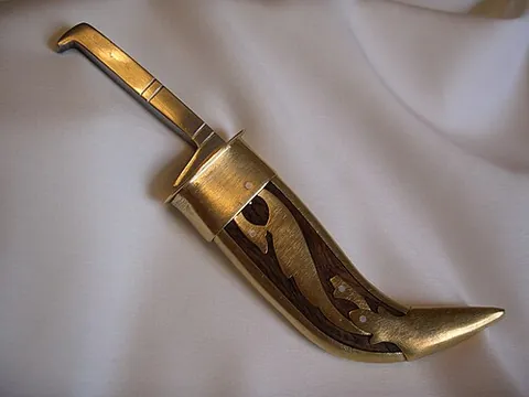 kirpan: a ceremonial sword that must be worn at all times by baptized Sikhs, and one of the five Ks