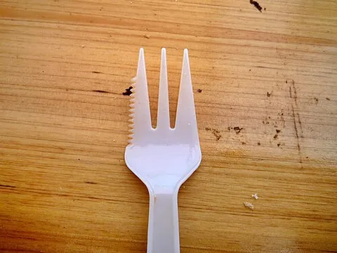 knork: a piece of cutlery in the form of a fork with a sharpened outer tine, enabling it also to be used...