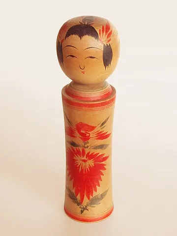 kokeshi: a Japanese wooden doll with a spherical head having simple painted-on features, and a limbless,...