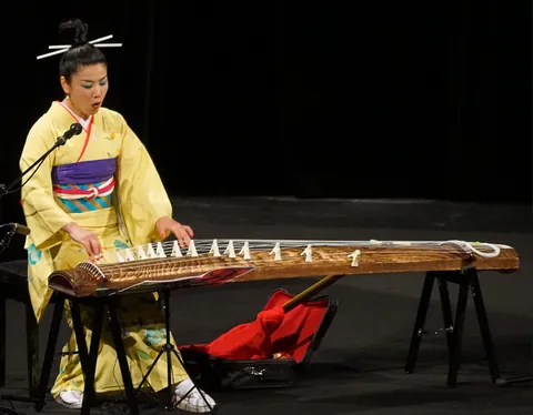 koto: a Japanese stringed instrument having numerous strings, usually seven or thirteen, that are...