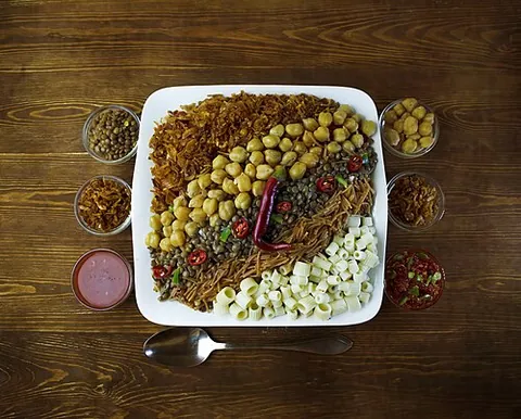 kushari: an Egyptian dish of rice, macaroni and lentils topped with a tomato-vinegar sauce and garnishes