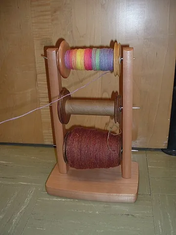 lazy kate: in spinning, a device used to hold one or more spools or bobbins in place while the yarn on them is...